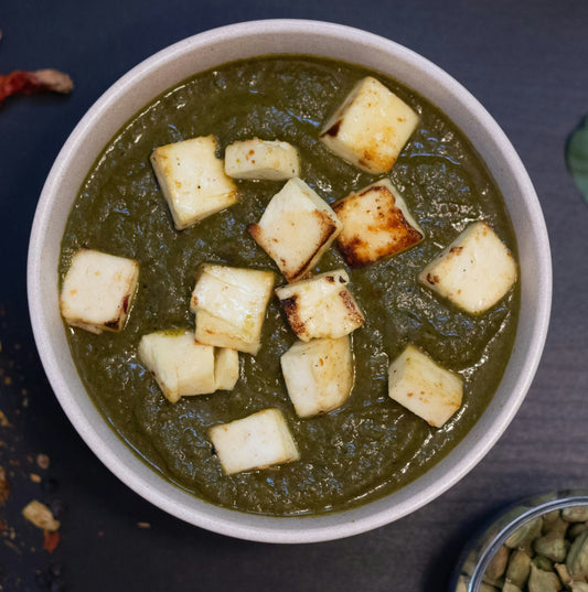 Spicey Saffron Palak Paneer – tender paneer cubes in a creamy spinach curry, served in a white bowl